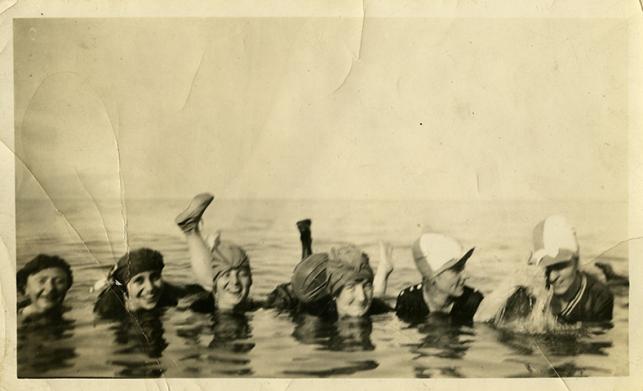 Scan of an old, creased photo, with 6 women swimming in a lake